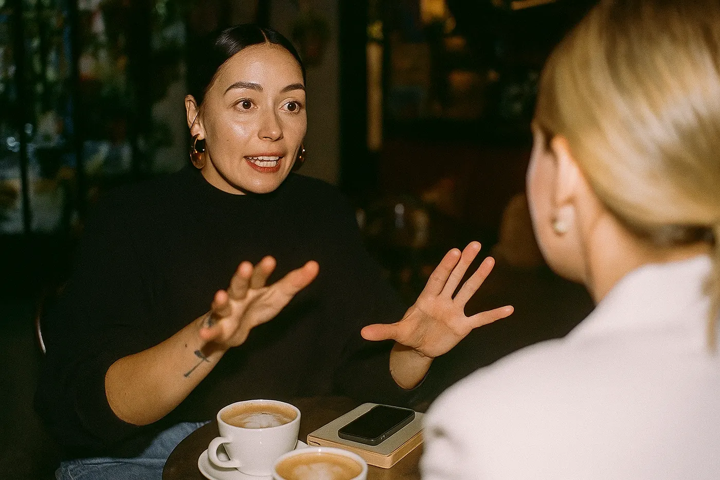 Broker in an animated conversation with a client over coffee